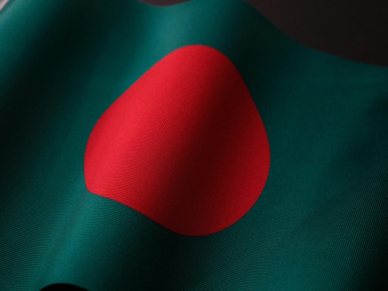 Close-up of the vibrant Bangladesh flag with rich colors and fabric texture.